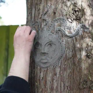 Clay face sculpted on tree