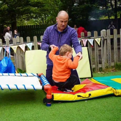Nursery child jumping off trampoline