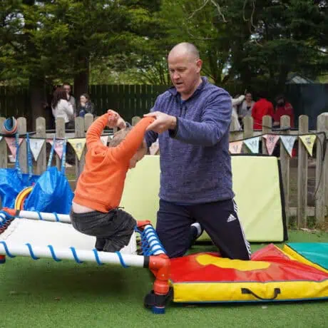 Staff supporting child on trampoline